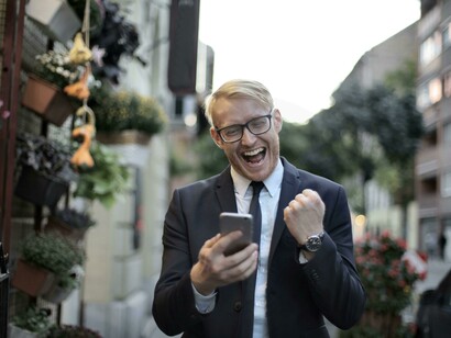 A man in suit shows great joy when accomplishing one of his goals through hard work