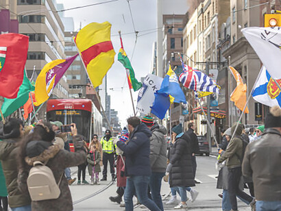 Vibrant scene at the Saint Patrick's Day parade, featuring people marching proudly with flags representing various counties across Ireland