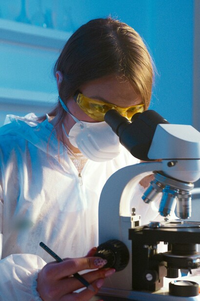 Uma mulher olhando pelo microscópio