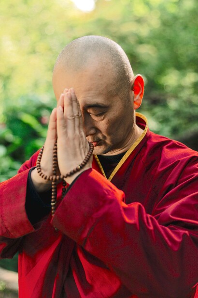 Monje faz posição de oração com as mãos