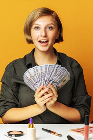 With a confident smile, the woman elegantly showcases a bunch of money in her hand, effectively promoting a line of exquisite makeup products, enticing viewers with both the allure of beauty and financial success