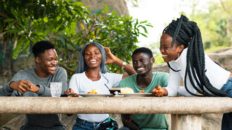 Friends share stories and smiles as they dig into a hearty meal of fufu, turning a simple gathering into a celebration of culture and connection