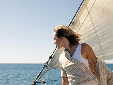 A woman stands on a boat, gazing at the Adriatic Sea during a luxurious sailing journey