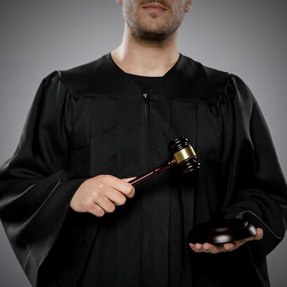A male judge holding a gavel, ready to preside over a court session