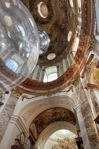 Blick vom Innenraum zum Deckenfresko von Johann Michael Rottmayr auf der Seite des Hauptaltars vorbei an der Installation „Aerocene“ von Tómas Saraceno © Mario Bogisch