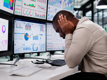 Surrounded by charts, notifications, and analytics, an exhausted office worker experiences the cognitive burden of constant digital engagement