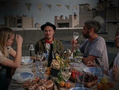 Persone che pranzano insieme sul terrazzo di un palazzo