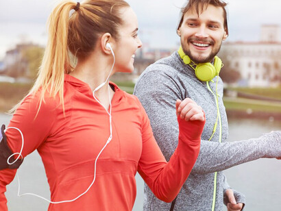 A happy couple exercising outdoors, enjoying a long-distance run together