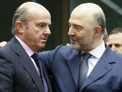 El ministro en funciones de Economía, Luis de Guindos, conversa con el comisario europeo de asuntos económicos, Pierre Moscovici