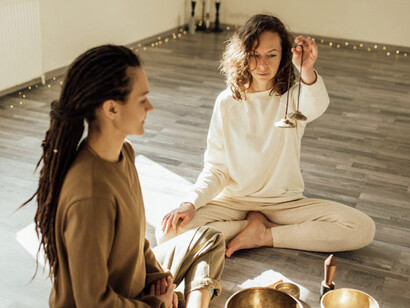 Two practitioners engage in alternative healing techniques, demonstrating the blend of ancient wisdom and contemporary methods in exploring the flow of universal life force energy