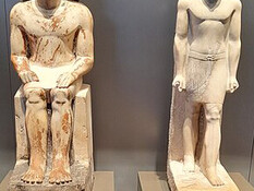 Statues of the official Metjetji from the Old Kingdom of Egypt, showcasing him in both seated and standing poses at the Grand Egyptian Museum in Giza, Egypt