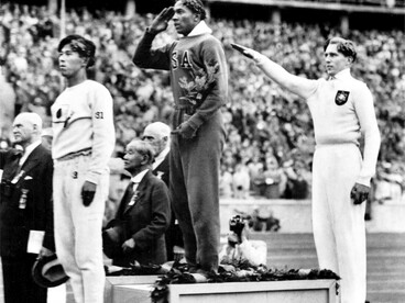 Il giapponese Naoto Tajima, terzo classificato, lo statunitense Jesse Owens, primo classificato e Lutz Long della Germania, che ha ottenuto il secondo miglior risultato alla premiazione per il salto in lungo ai Giochi Olimpici di Berlino 1936