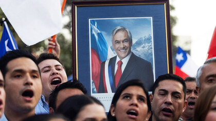Ciudadanos chilenos sostienen un cuadro del presidente Sebastián Piñera, en honor a su memoria