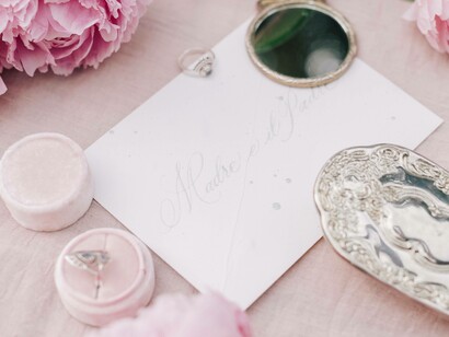 A love letter unopened surrounded by pink roses and artifacts 