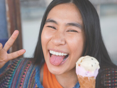 Joyful Central American woman enjoying a creamy ice cream, highlighting the rich cultural essence and relaxation of the region