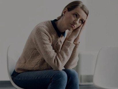 A young woman, deep in thought, awaits the beginning of a group therapy session