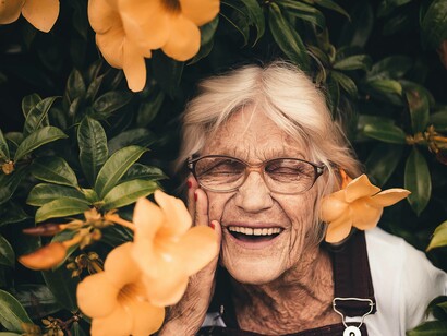 An elderly woman is embracing all that life has to offer her in her current state