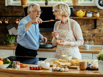 Happy elderly couple dancing together in the kitchen