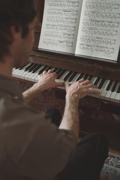 Homem toca piano em apresentação intimista