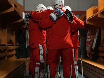 Players huddling closely in the locker room before a game, symbolising camaraderie without the expectation of unconditional permanence