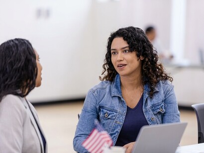 Election staff use a laptop to help voters check in at a polling station in the United States