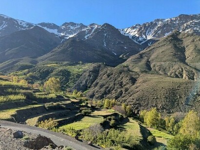 The Atlas Mountains stretching beyond the valley, representing Morocco's diverse landscapes and identities