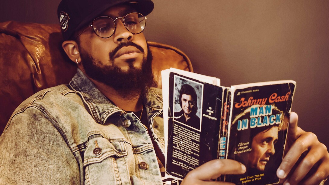 Homem lê biografia de Johnny Cash. Por meio da vida de uma pessoa, podemos vislumbrar os dilemas, os valores e as transformações de uma época. A biografia nos permite explorar o tecido da história de forma íntima, conectando eventos e contextos ao mundo concreto das escolhas e ações individuais