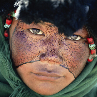 Kazuyoshi Nomachi, Tibet, Una ragazza nomade con il volto cosparso di una sostanza protettiva durante un pellegrinaggio, Tibet, Cina 1990 © Kazuyoshi Nomachi
