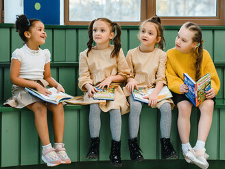 Crianças brincam de ler o livro em voz alta uma de cada vez
