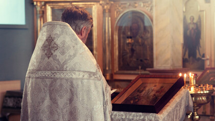 Padre lê documento milenar dentro da igreja do Vaticano, na Itália