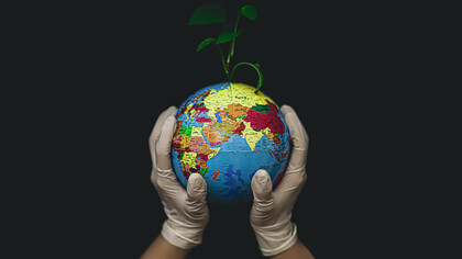 Cradling the Earth in gloved hands, a promising seed begins to sprout