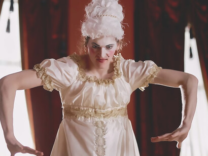 A man theatrically adorned in women's attire, embracing a dramatic and expressive fashion statement