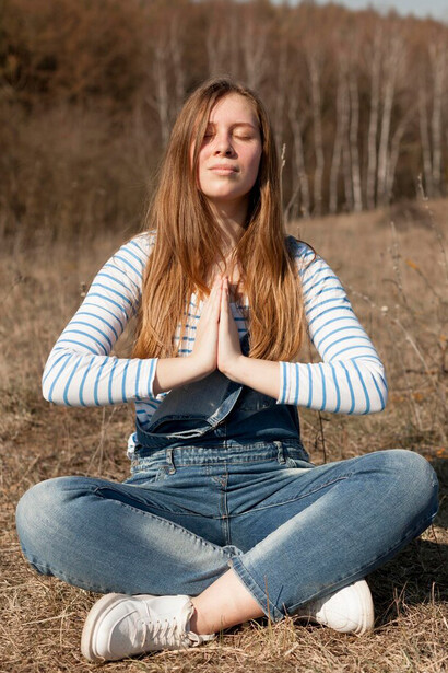 From a side view, a woman relishes her time in nature, fully immersed in the serene beauty of her surroundings