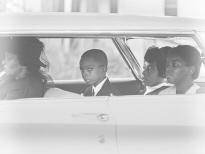 A family of African Americans traveling by car, the young boy looks scared and worried