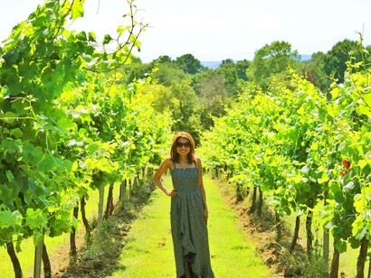 A woman posing near one of Great Britain's best vineyards to visit during the summer holidays