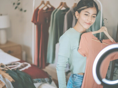 An influencer, actively engaging in affiliate marketing, elegantly showcases a product she's endorsing to her audience