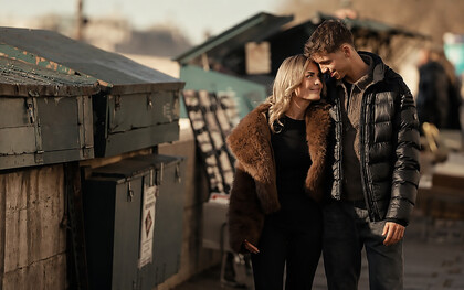 Young couple enjoying a romantic walk beside a dumpster in a gritty urban alley