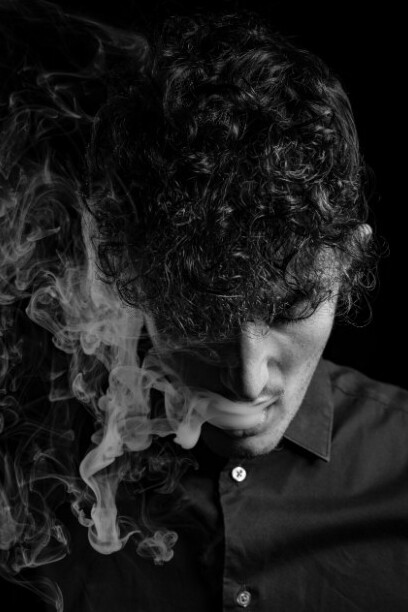 A person wearing a black long-sleeve shirt is smoking