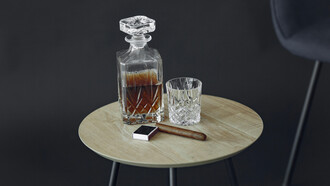 An engraved bottle of bourbon and a cigar, symbols of status