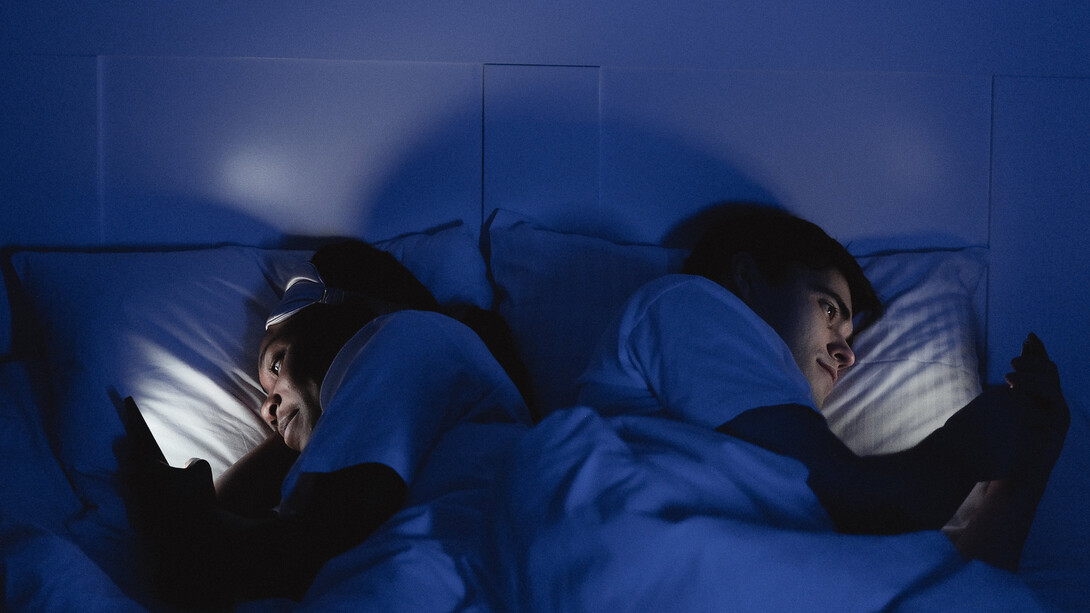 Casal na mesma cama recebem mensagens nos celulares