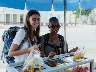 Women choosing street food from a market stall in Asia