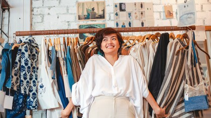 Moça alegre em loja de roupas secondhand