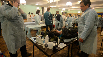 Medici volontari prestano assistenza ai feriti in un ospedale di fortuna. Scontri a Kiev, Ucraina. Eventi del 18 febbraio 2014