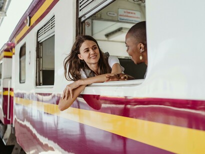 Women looking out the train window and chatting on public transport