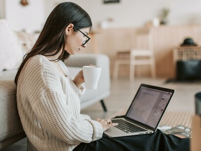 A writer working on her novel and holding a hot drink 