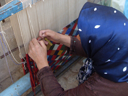 Hiladora mostrando la estructura de alfombra iraní