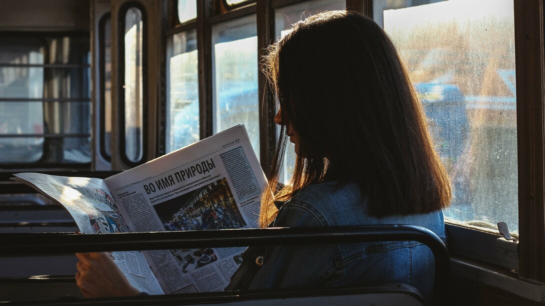 Informazione, donna legge un giornale in lingua russa