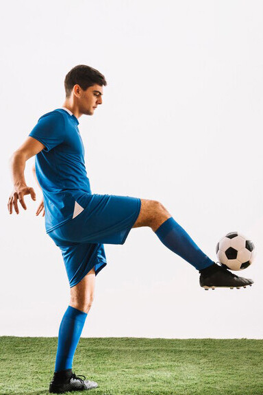 A soccer player is balancing a ball on their foot