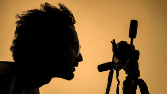 Fotógrafo mira a través del lente de una cámara