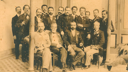 Foto dos integrantes da “panelinha”, criada em 1901 para a realização de festivos ágapes e encontros de escritores e artistas. A fotografia é de um almoço no Hotel Rio Branco (1901), que ficava na Rua das Laranjeiras. De pé: Rodolfo Amoedo, Artur Azevedo, Inglês de Sousa, Bilac, Veríssimo, Bandeira, Filinto de Almeida, Guimarães Passos, Valentim Magalhães, Rodolfo Bernardelli, Rodrigo Octavio, Heitor Peixoto; sentados: João Ribeiro, Machado, Lúcio de Mendonça e Silva Ramos